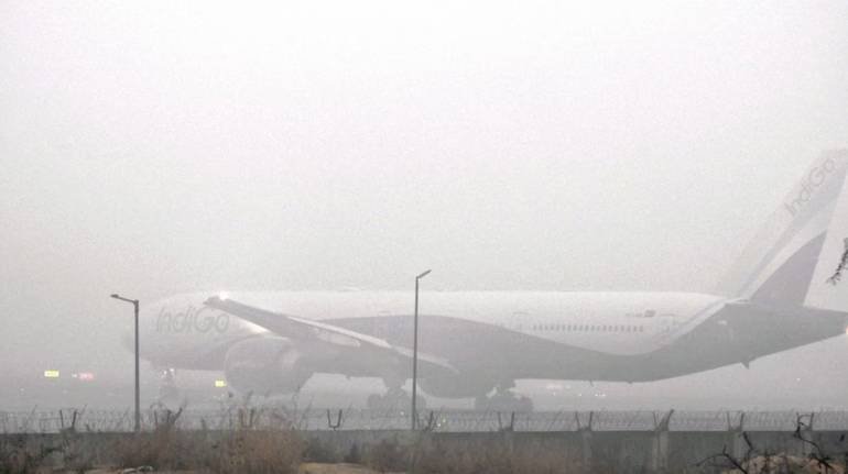 Air traffic control tower operating in dense fog at an Indian airport in winter