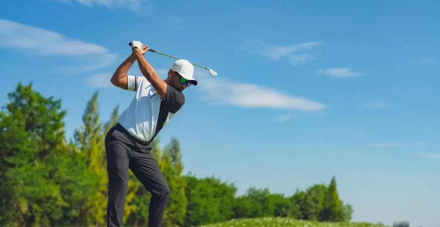 Golfer swinging on a lush green golf course symbolizing fitness and focus