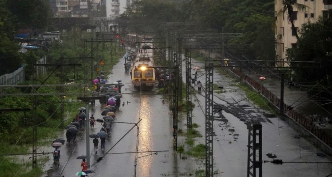 “Waterlogged Mumbai local train tracks with stranded commuters”