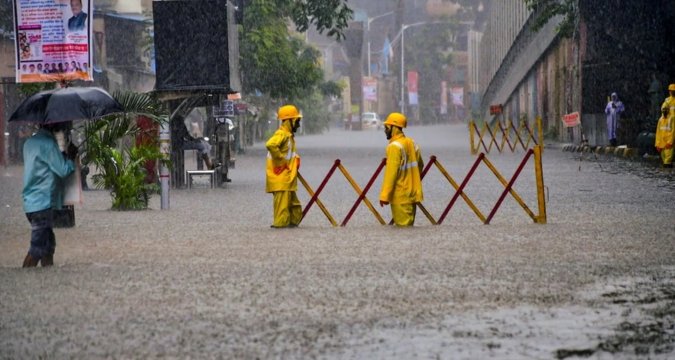 Mumbai skyline with dark monsoon clouds and rainfall forecast warning