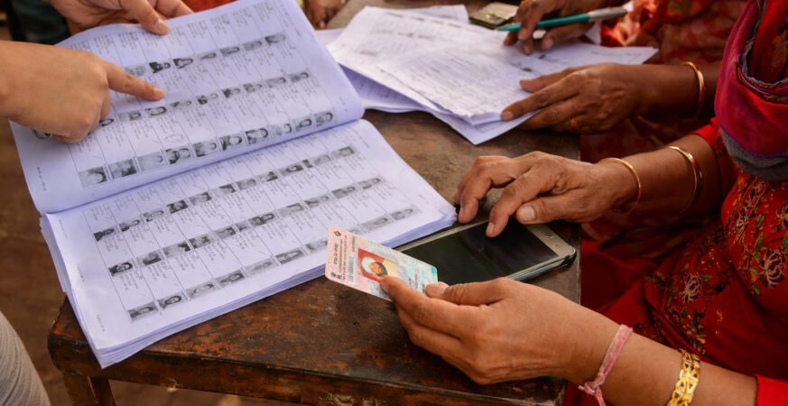 Indian voters standing in queue for voter list verification during SIR process